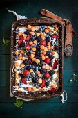 Blechkuchen mit Lavendel, Vanilleglasur, frischen Beeren und roten Pflaumen