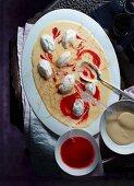 Poached meringues on custard with strawberry purée (view from above)