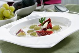 Ajoblanco (cold garlic and almond soup, Spain) garnished with grapes and figs