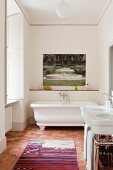 A traditional tomette tiled floor in white bathroom with artwork by Martini Maggi