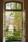 View through open windows out to garden with topiary and fountains