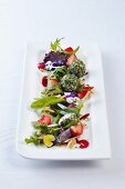 A salad of flowers in rose honey vinaigrette with goat's cheese balls