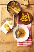 Clear fish stock, Biskuit-Käseschöberl (cheese sponge soup accompaniments), Tirteln (deep-fried pastries from South Tyrol) filled with quark and bacon dumplings