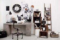 Black and white vintage decor, wooden crates, ladder and wall clock above concrete-effect desk; wood panelling used as pinboard