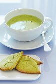 A cup of matcha tea with leaf-shaped matcha biscuits