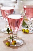 Glasses of rosé wine decorated with ornamental apples