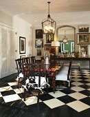 Dining room with exotic wood table and upholstered wooden chairs on chequered, tiled floor