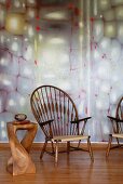 Peacock chair and artistic side table in exotic wood against wall design in pastel shades