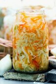 White cabbage and carrot salad with red peppers in jars