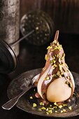 Poached pear with chocolate sauce and pistachios