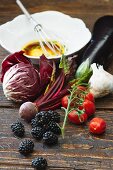 Verschiedene Gemüsesorten, Brombeeren und Vinaigrette auf Holztisch