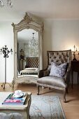Neo-classical armchair next to antique wardrobe with mirrored door