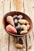 Assorted varieties of potato in a wooden bowl