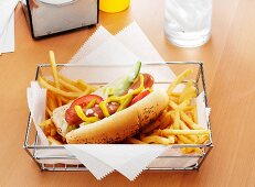 A Hot Dog with the Works and French Fries in a Metal Basket