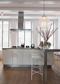 Modern kitchen island with breakfast bar in front of large windows