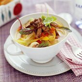 Vegetable soup topped with peppers and beef