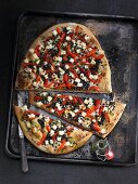 A lentil pizza with grilled peppers and sheep's cheese