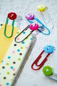 Colourful miniature buttons decorating paperclips