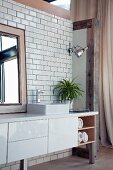 Washstand with white base cabinet on metal legs against tiled wall