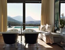 Luxurious bathroom with free-standing twin bathtubs and magnificent view of landscape