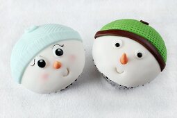 Zwei lustige Cupcakes mit Schneemanngesichtern