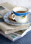 Vintage Teetasse und Teller mit Keksen auf Zeitung