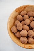 Kakao-Schokoladen-Bonbons in einer Holzschale (Draufsicht)