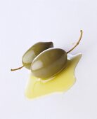 Ein Klecks Olivenöl mit Oliven