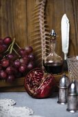Stillleben mit Fischkarkasse, Granatapfel, Trauben und Rotwein