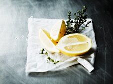 Zitronen und frischer Thymian auf Tuch