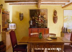 A dining room in a country house with a wooden table and Asian pieces of art
