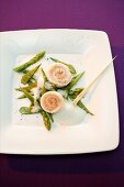 Steamed sole and salmon rolls on green vegetables with a foam sauce