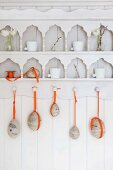 Easter eggs with orange ribbons hanging from ornate kitchen shelving