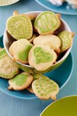 Bowl of apple-shaped biscuits with green icing