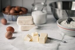 Chunks of butter, flour, sugar and eggs for baking biscuits