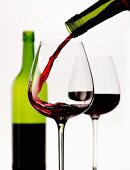 Rotwein wird in Glas eingeschenkt