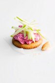 A cracker topped with beetroot and apple