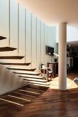 Pattern of light and shade cast by airy, floating stair treads attached to baluster rods below mezzanine level