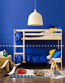 Blaues Kinderzimmer für zwei - mit Hochbett aus Naturholz, Korblampe und Holzspielzeug auf Webteppich