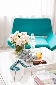 Crystal candlestick on tray table in front of turquoise lounge chair