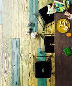 Tisch & schwarze Retro-Metallhocker in Wohnraum mit unterschiedlich eingefärbten Fliesen in Holzdielenoptik