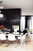 Charcoal-grey partition between living room and dining room with Eames chairs