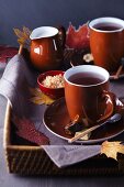 Tray of teacups, sugar and milk decorated with autumn leaves