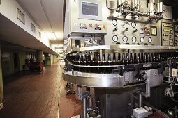 Bottles being filled by a machine in an industrial brewery