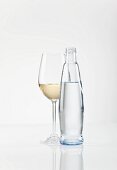 Weissweinglas neben einer Wasserflasche