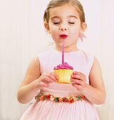 Young girl holding a birthday cupcake