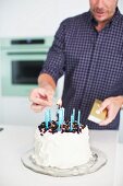 Vater zündet Kerzen auf Torte für 1. Geburtstag an