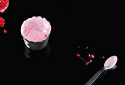 Yogurt and pomegranate seeds on black background