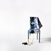 Chair with unusual cover made from patchwork of jeans pockets on the left side and floral patterns on the right