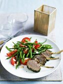 Lamb chops with a herb crust, green beans and tomatoes